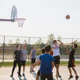 Group of boys playing basketball outdoors